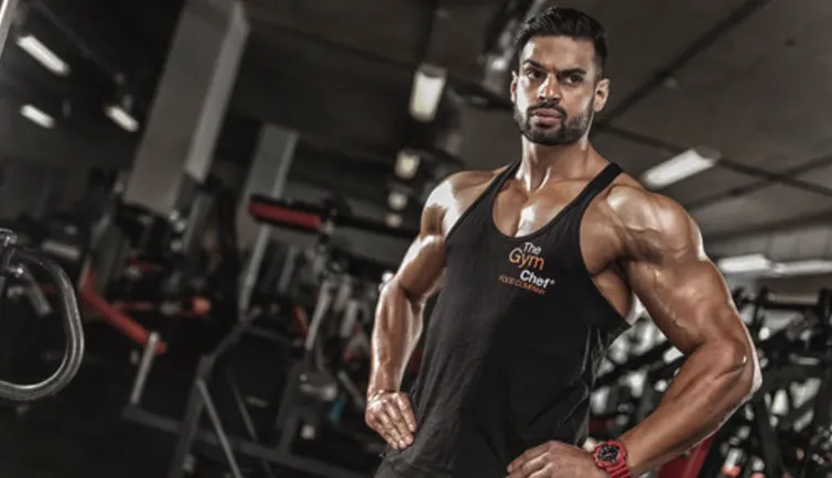 Juggy Sidhu standing in a gym wearing a black vest top